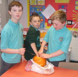 Odhran, Aaron and Curtis carve a pumpkin